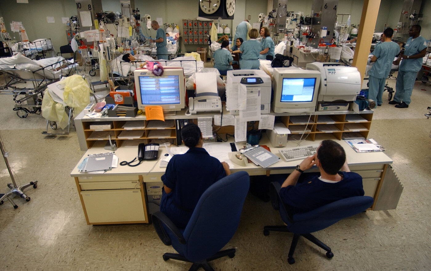 A central monitoring station: one screen, many patients, every one of them generating the vitals a sepsis model ingests. Scale up the alerting and you scale up the false alarms in lockstep. This is the environment a sepsis warning has to earn attention in, and most of them don’t. US Navy photo by Shane T. McCoy, public domain, via Wikimedia Commons.